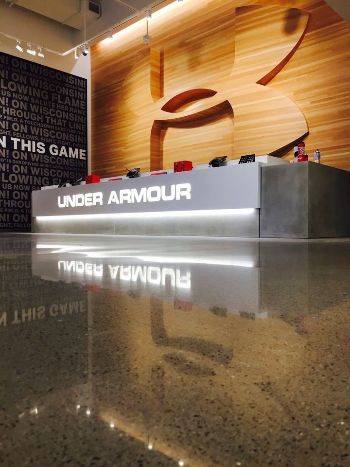 Under Armour store display with glowing logo and reflection on polished floor