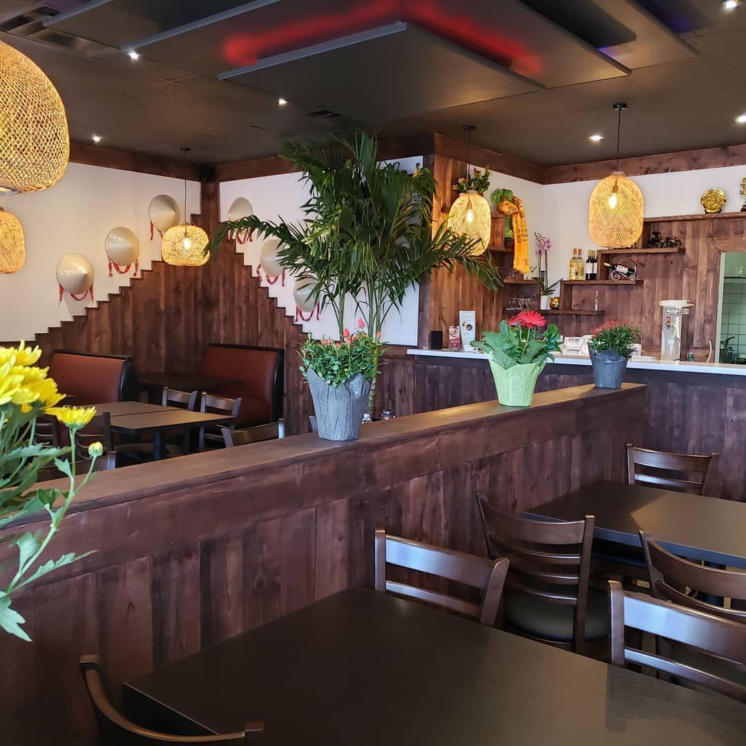 A restaurant with tables and chairs and potted plants