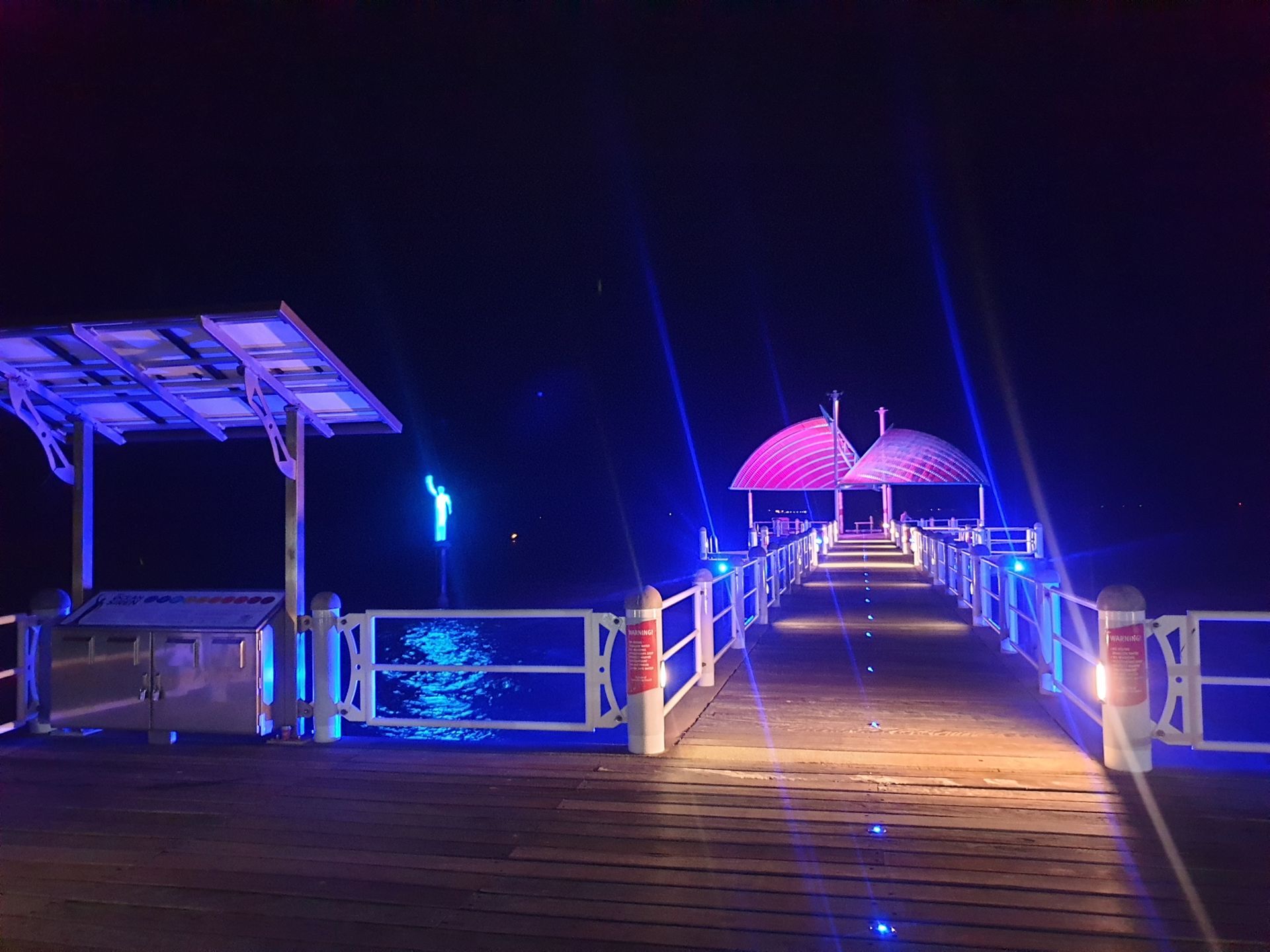 A Bridge With Shade Covers Lit Up With Coloured Lights At Night— Lex Electrix In West End, QLD