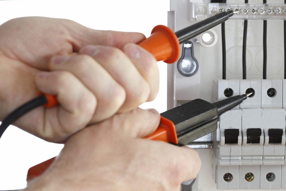 A Person Is Working On A Circuit Board With A Pair Of Pliers โ Lex Electrix In West End, QLD