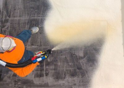 A man is spraying foam on a wall.