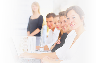 A group of people are sitting at a table with laptops.