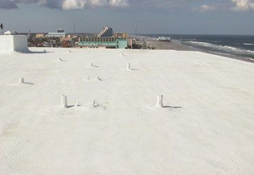 A white roof with a view of the ocean and a beach.