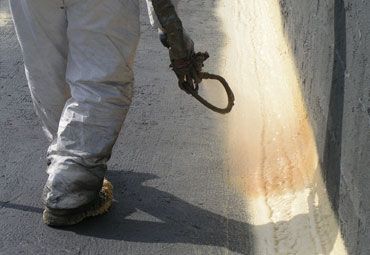 A person is spraying foam on a wall.