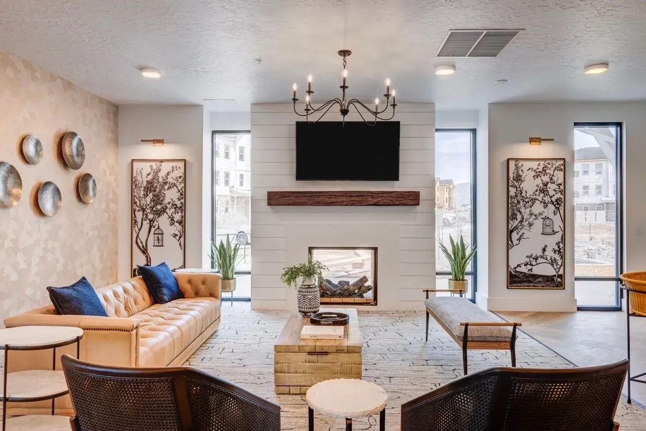 Stylish lounge area with a fireplace, comfortable seating, and large windows at Aria in Syracuse, UT.