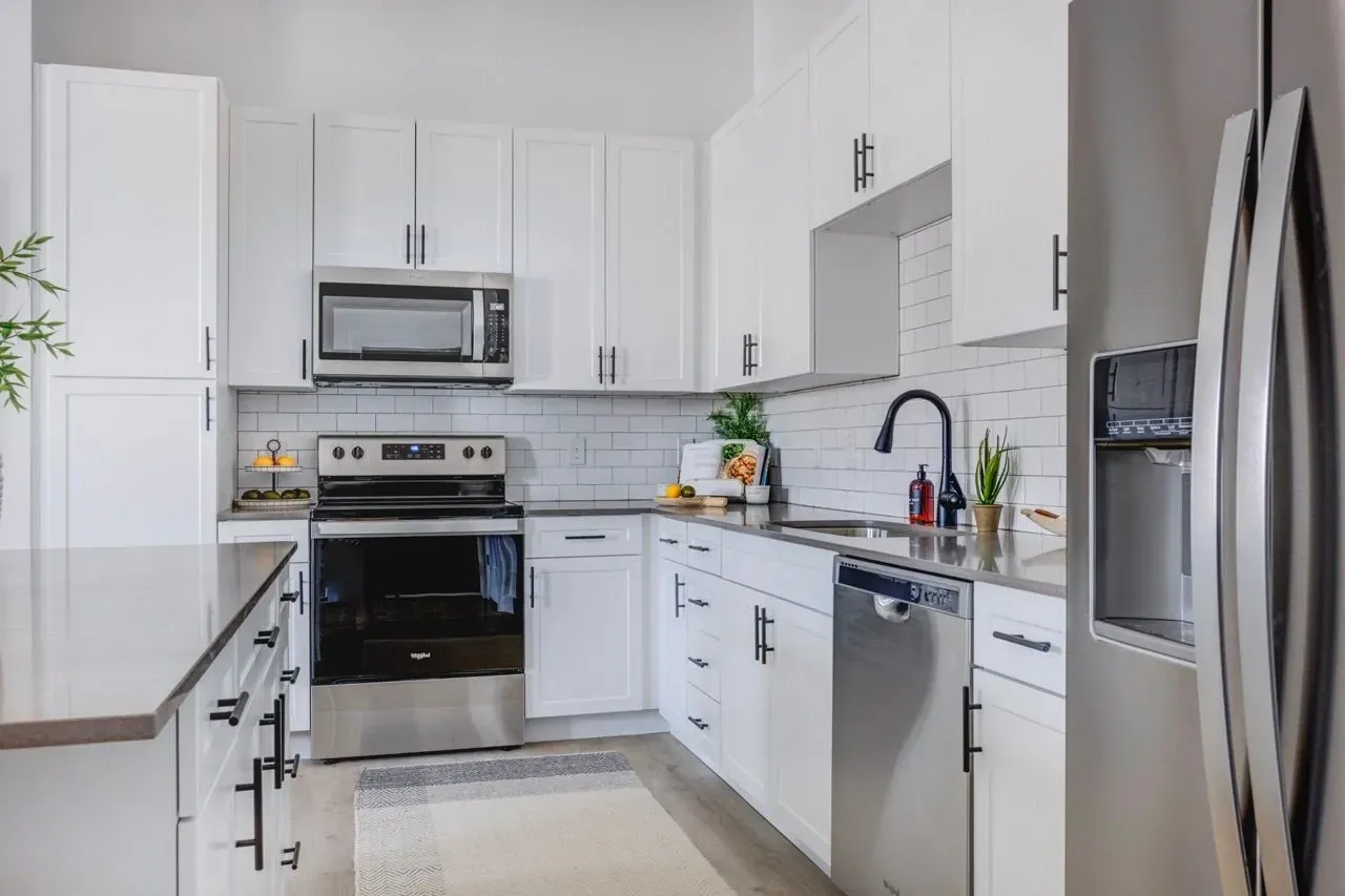Modern kitchen with white cabinets, stainless steel appliances, and subway tile backsplash at Aria in Syracuse, UT.