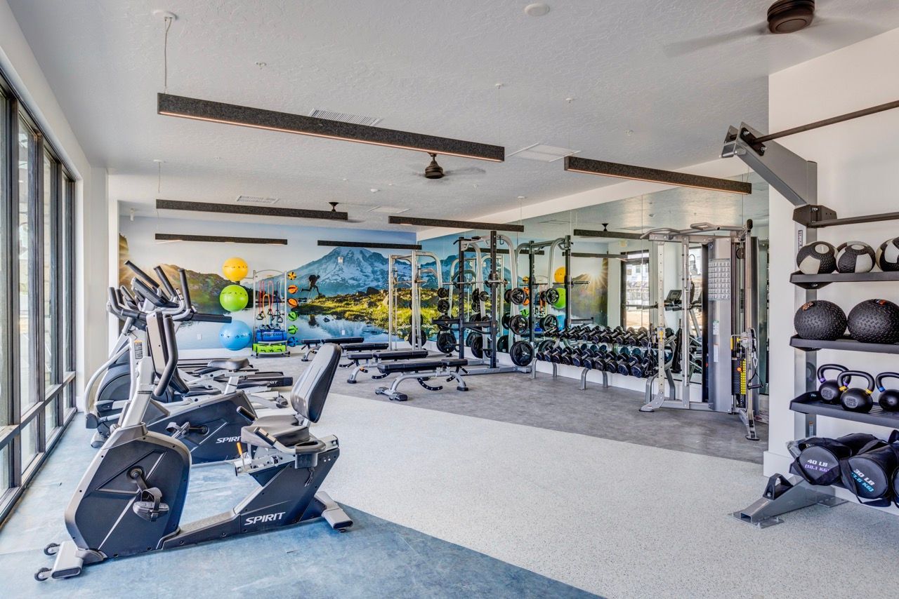 Aria on-site fitness center with cardio machines, free weights, and a wall mural.