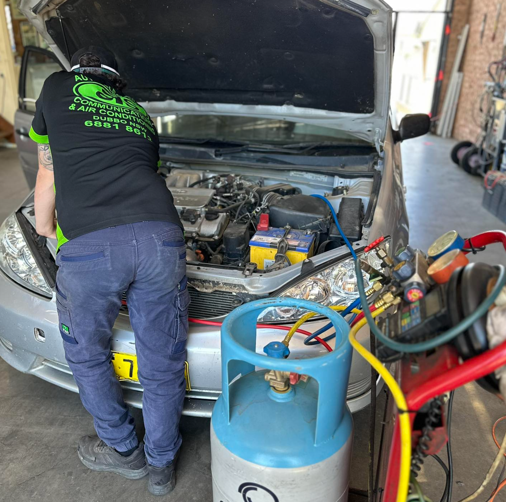 A man is working under the hood of a car