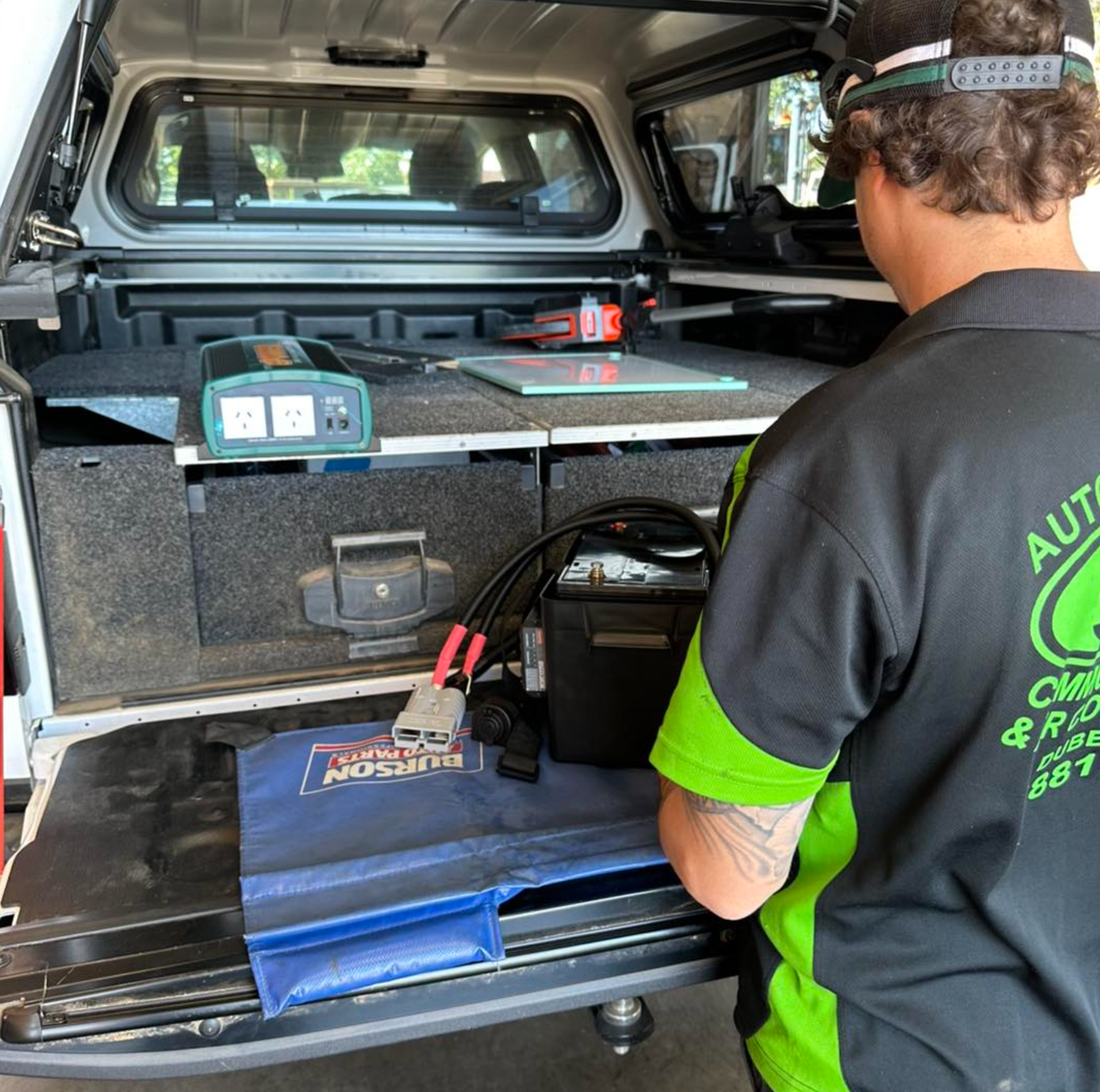 A man in a green and black shirt with the word auto on the back
