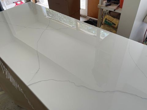 White countertop or tabletop with visible gray cracks in a bright indoor room