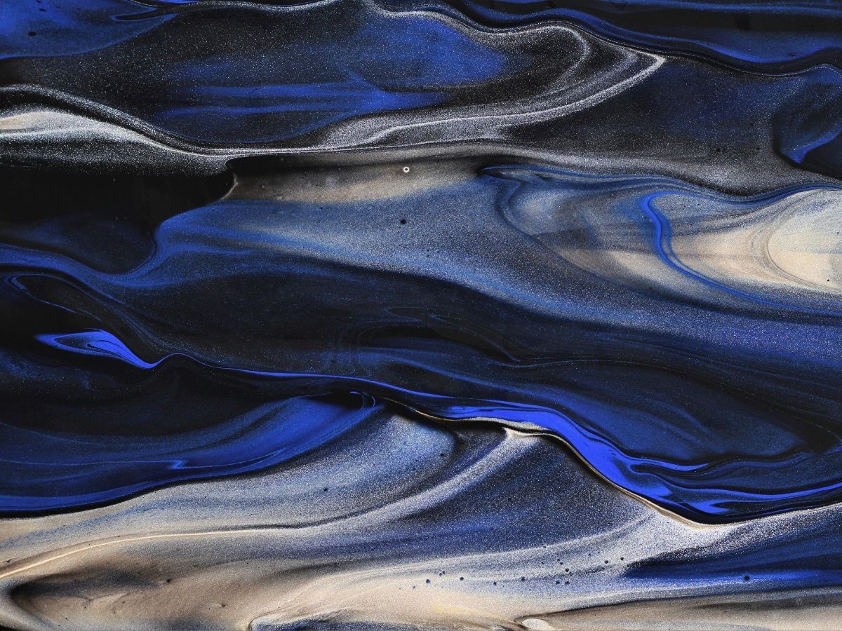 Abstract blue, black, and white fluid waves swirling in layered marbled patterns