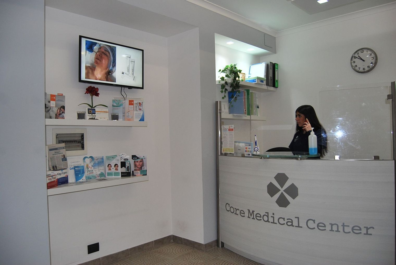 Una donna è seduta allo sportello di un centro medico.
