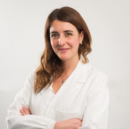 Una donna in camice bianco con le braccia incrociate
