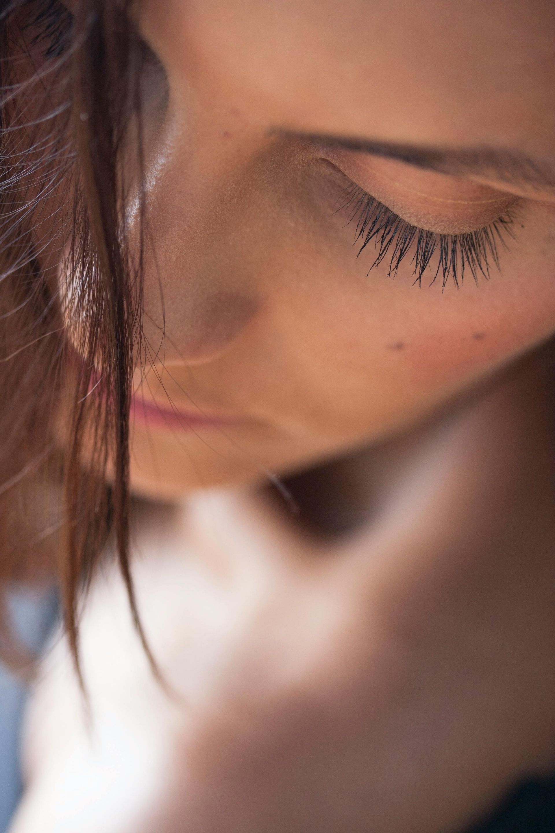 Un primo piano del viso di una donna con gli occhi chiusi.