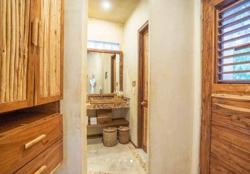 Bathroom with wooden cabinets and sink, natural tones.