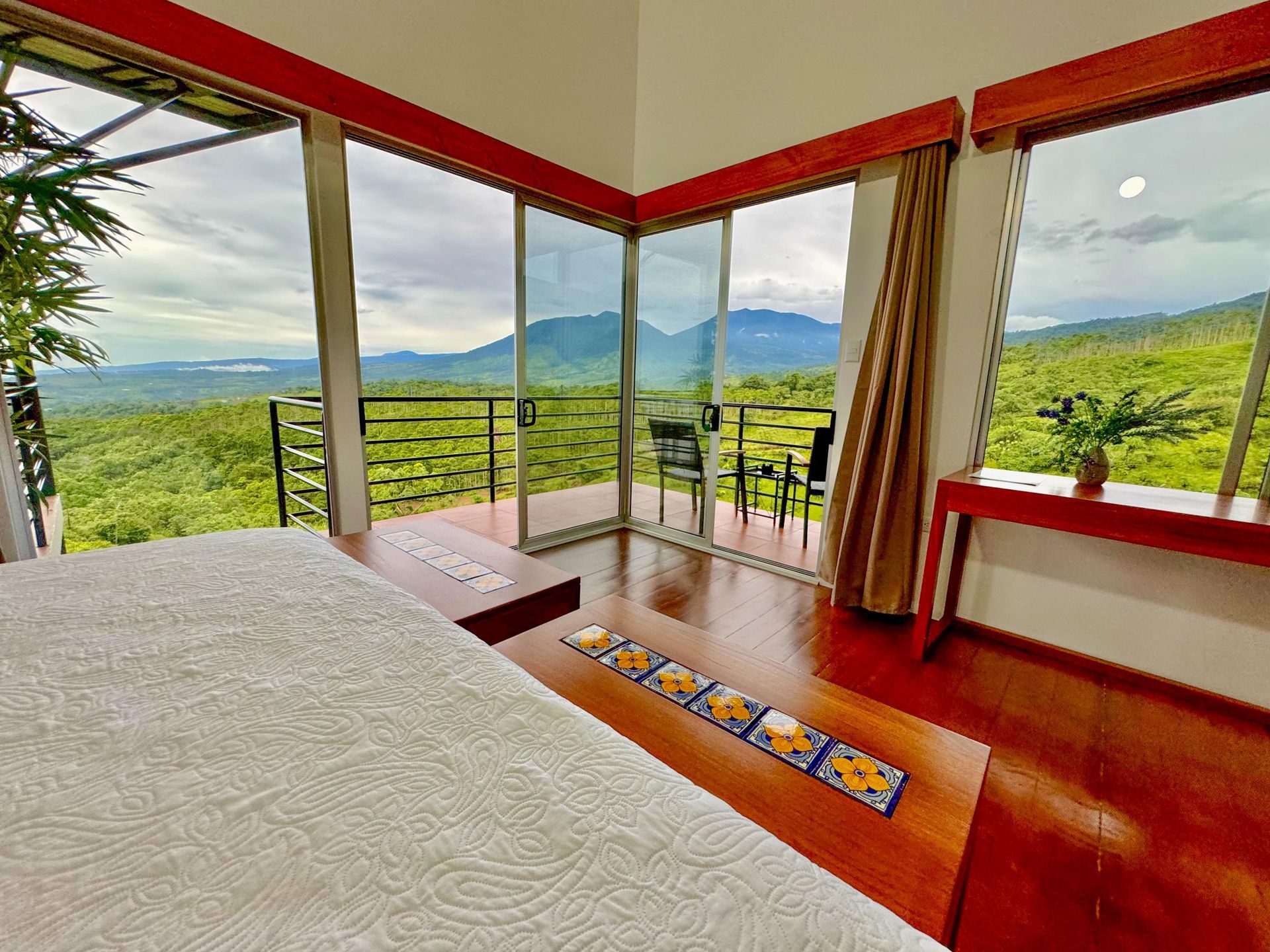 A bedroom with a large bed , a lamp , a table and chairs.