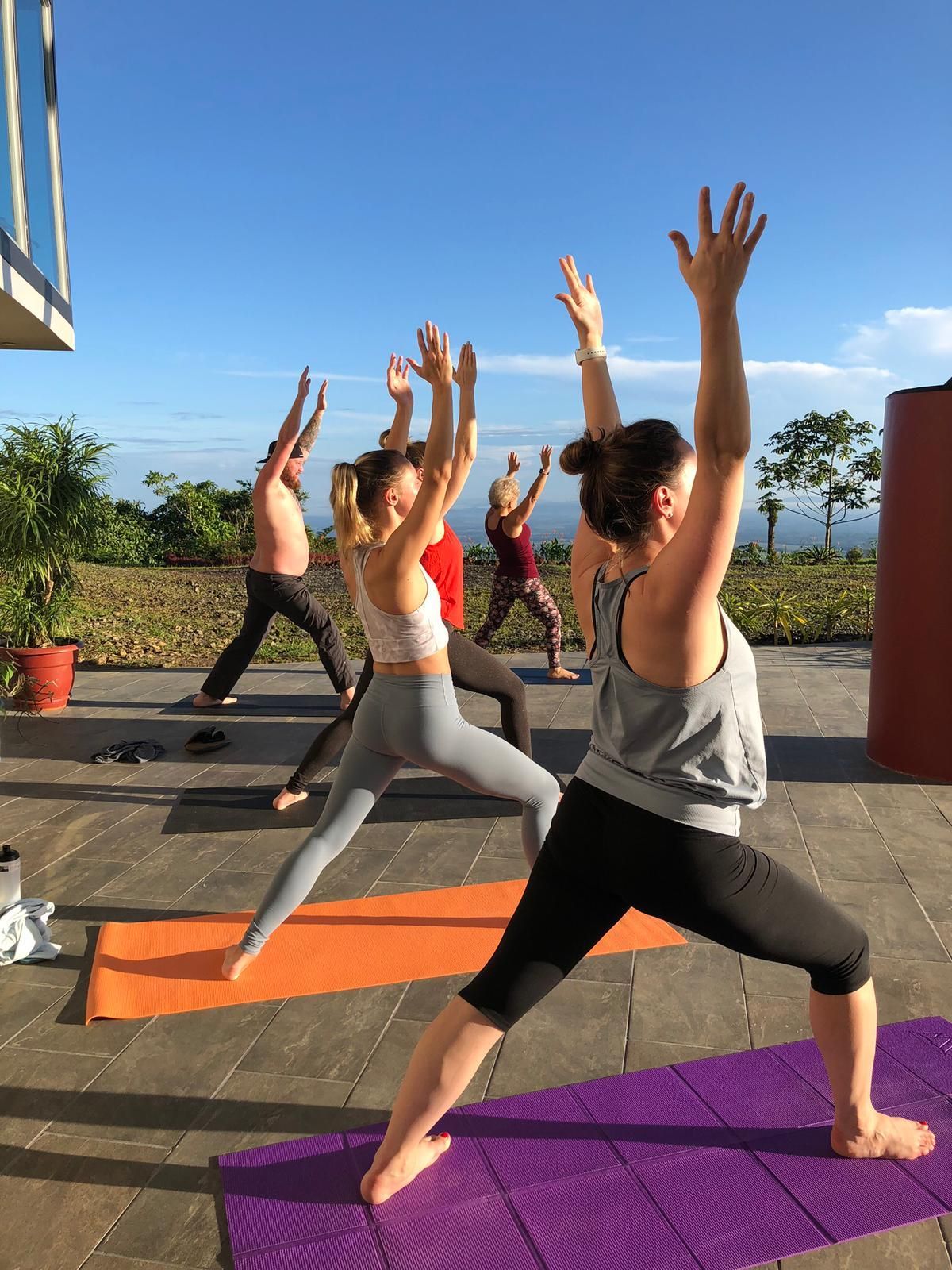 A group of people are doing yoga on a patio.