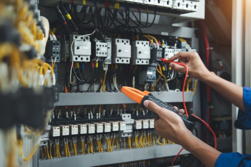 An Electrician is Working on an Electrical Panel With a Multimeter — Maratustech In Woy Woy, NSW