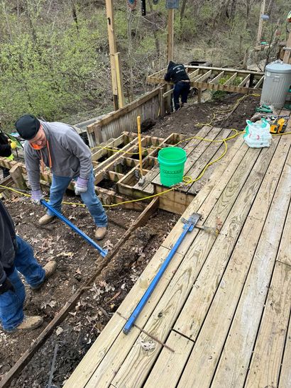 A group of people are working on a wooden deck.