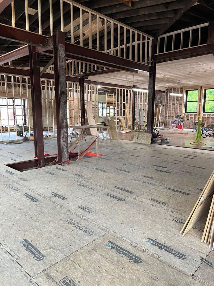The inside of a building under construction with a wooden floor.