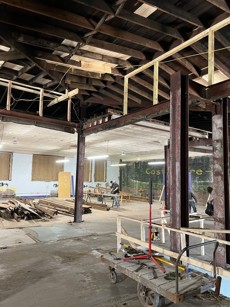 A building under construction with a cart in the middle of the room.