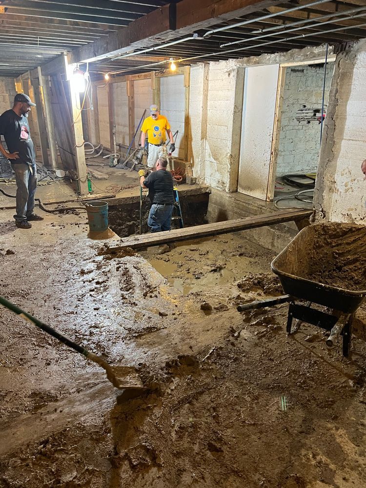A group of people are working in a muddy basement.