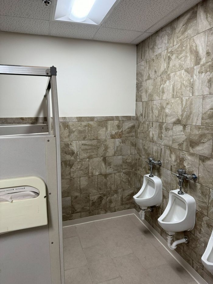 Three urinals are lined up in a public restroom.
