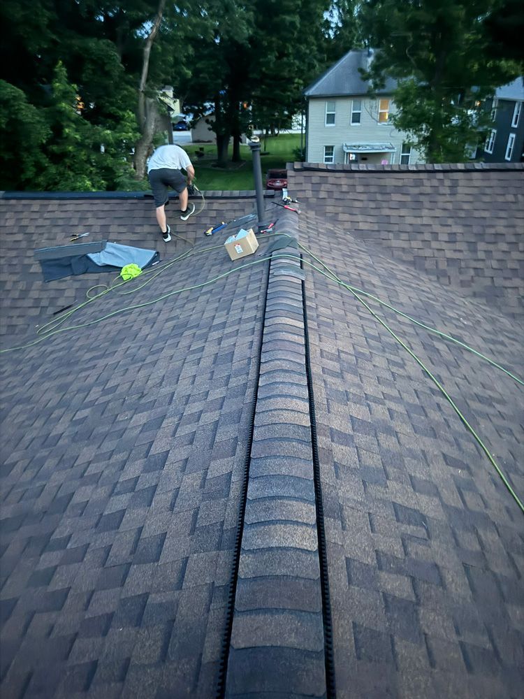 A man is working on the roof of a house.