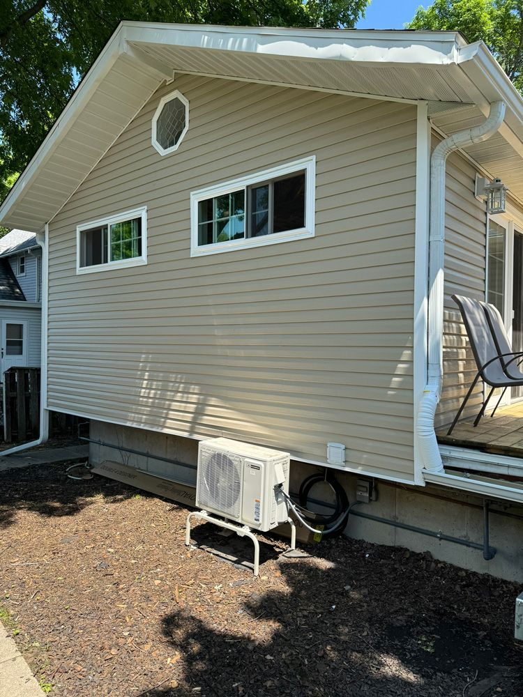 A house with a large window and a small air conditioner on the side of it.