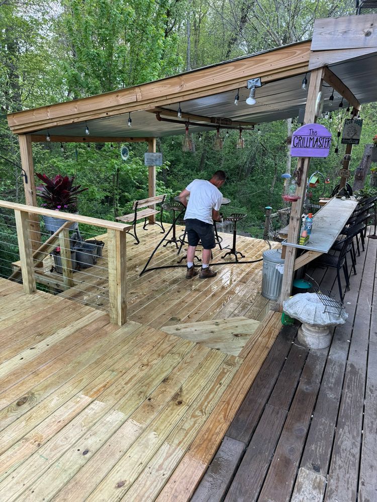 A man is cleaning a newly installed wooden deck.