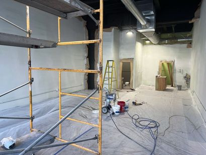 An empty room with scaffolding and a ladder in it.