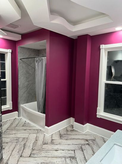 A bathroom with purple walls and a bathtub.