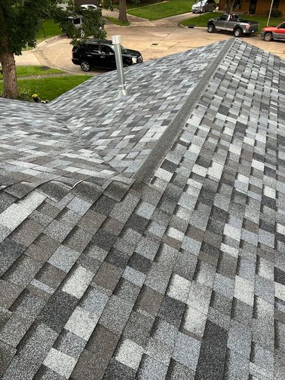 A roof with a lot of shingles and a chimney on it.