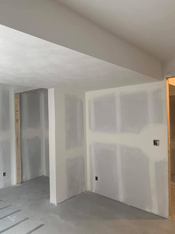 An empty room with drywall on the walls and ceiling.