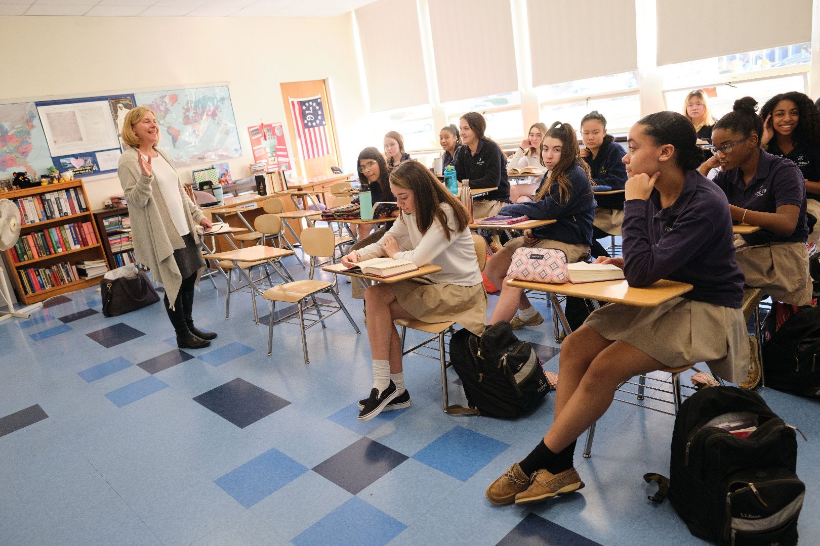 a teacher stands in front of a classroom full of students