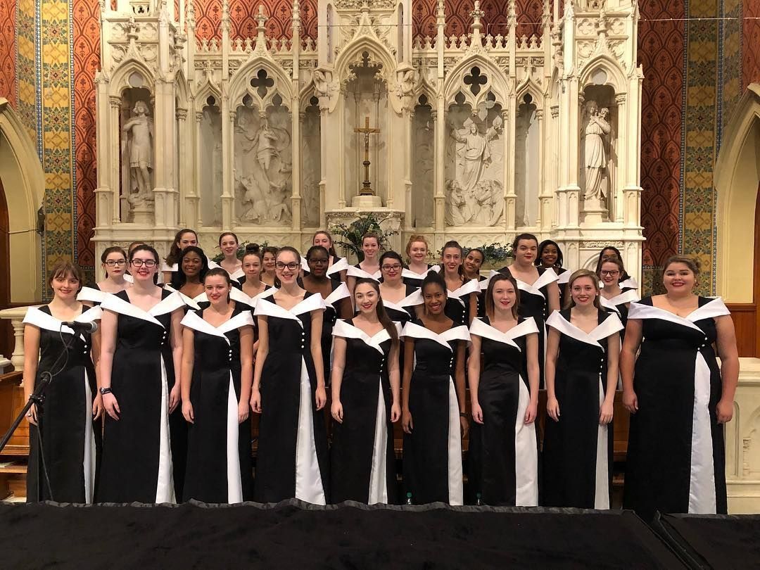 a choir is posing for a picture in front of a church altar .