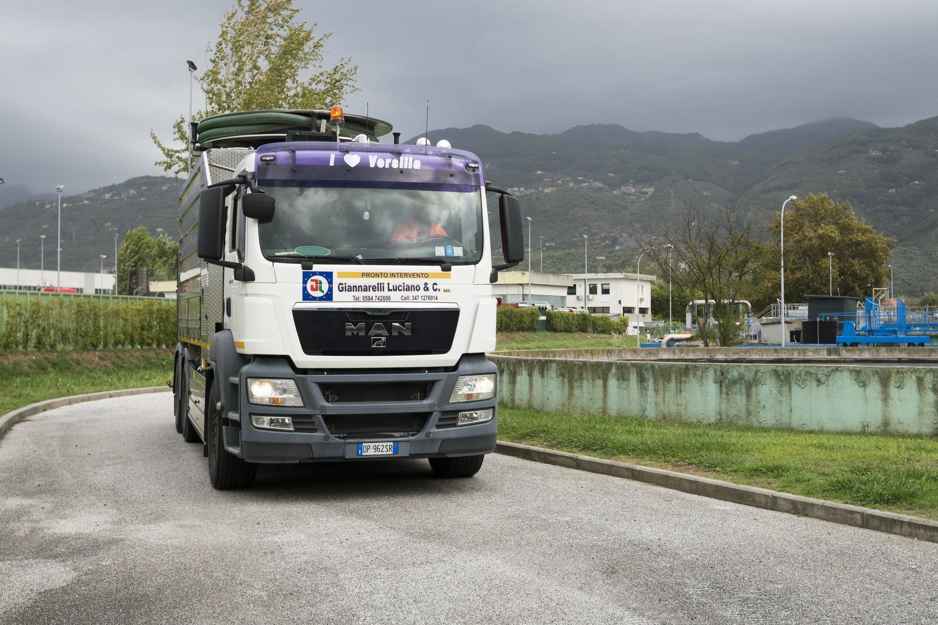 Camion bianco per il trasporto dei rifiuti su una strada.