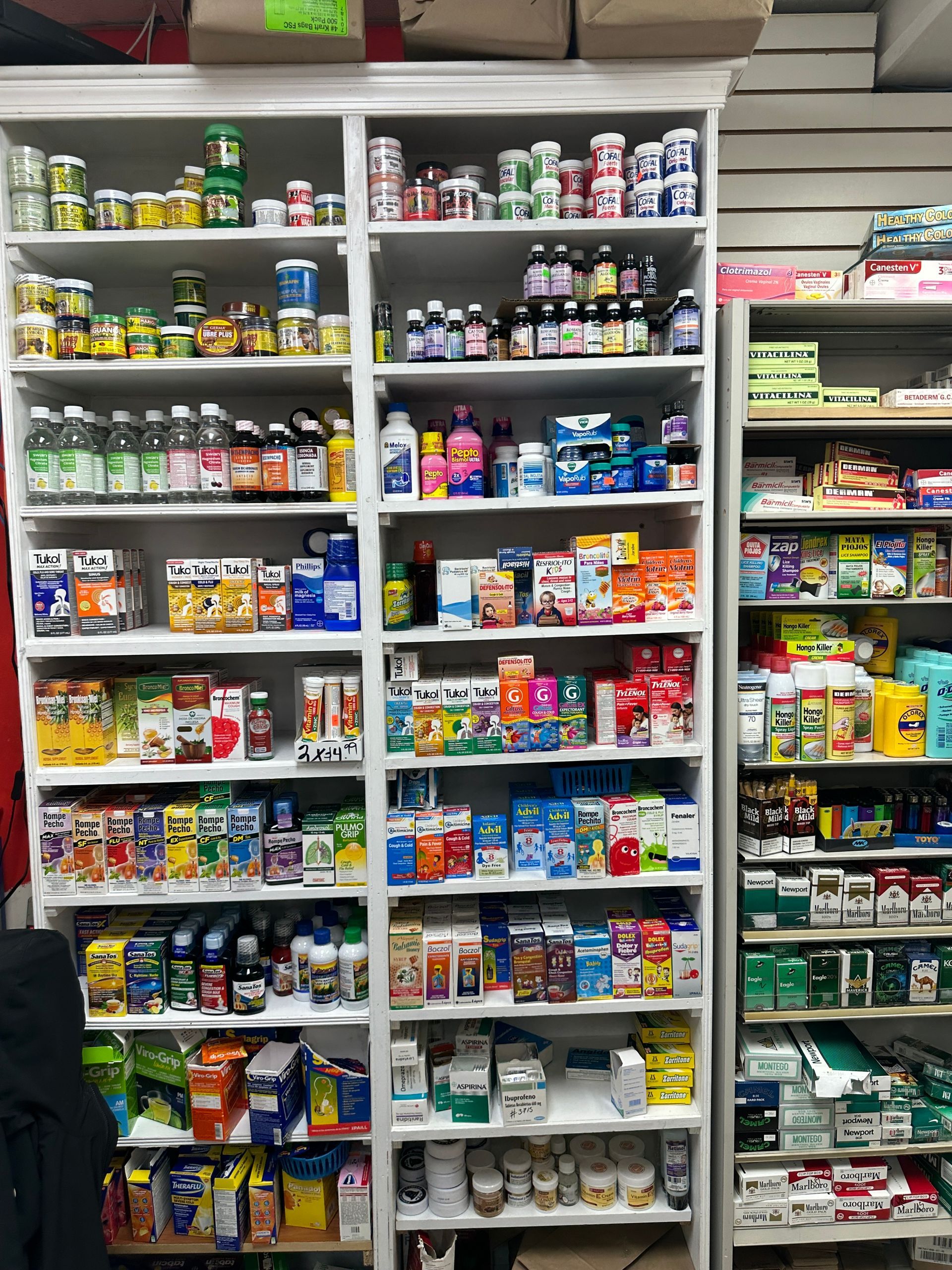 Shelves packed with various bottles and boxes of medicine and supplements in a store.