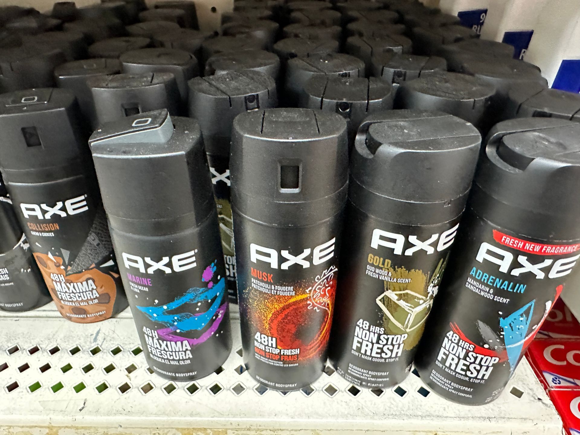 A display of Axe body spray cans in various scents on a store shelf.
