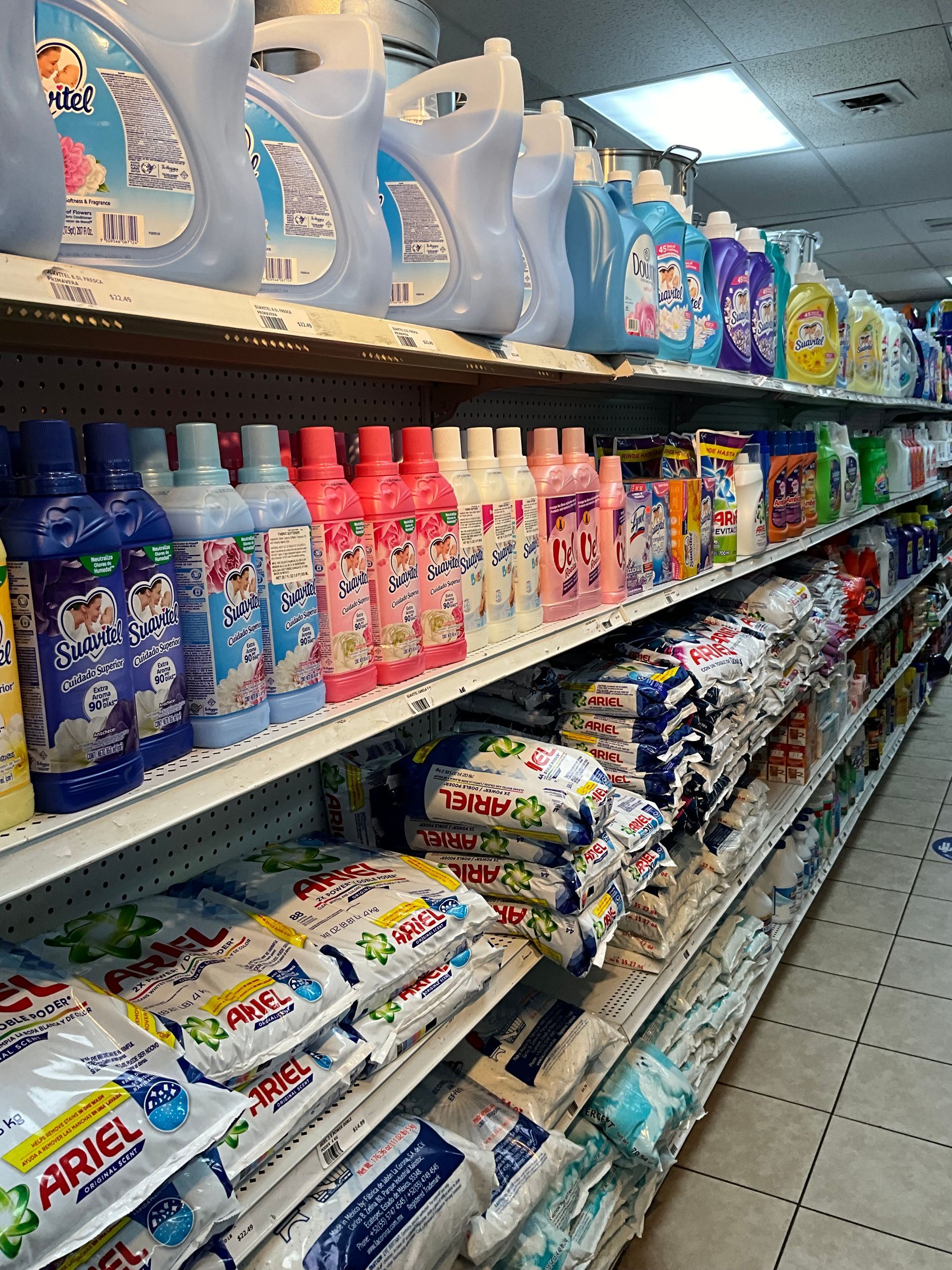 Shelves stocked with various laundry detergents and washing powders in a store.