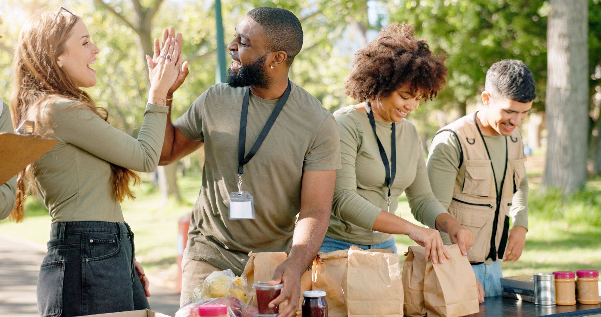 A group of people are standing around a table giving each other a high five.