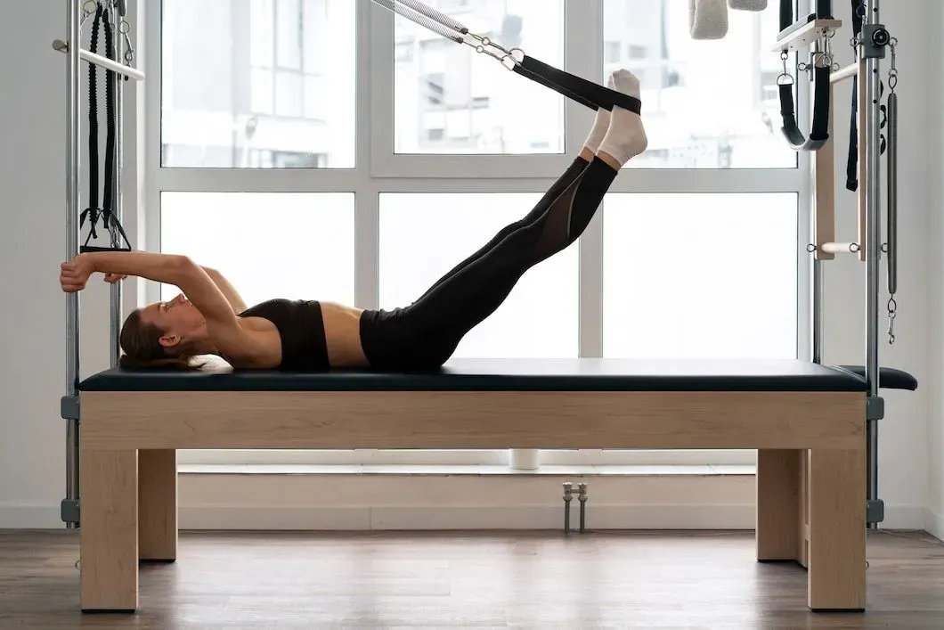 Woman smiling during Pilates on a reformer in a studio
