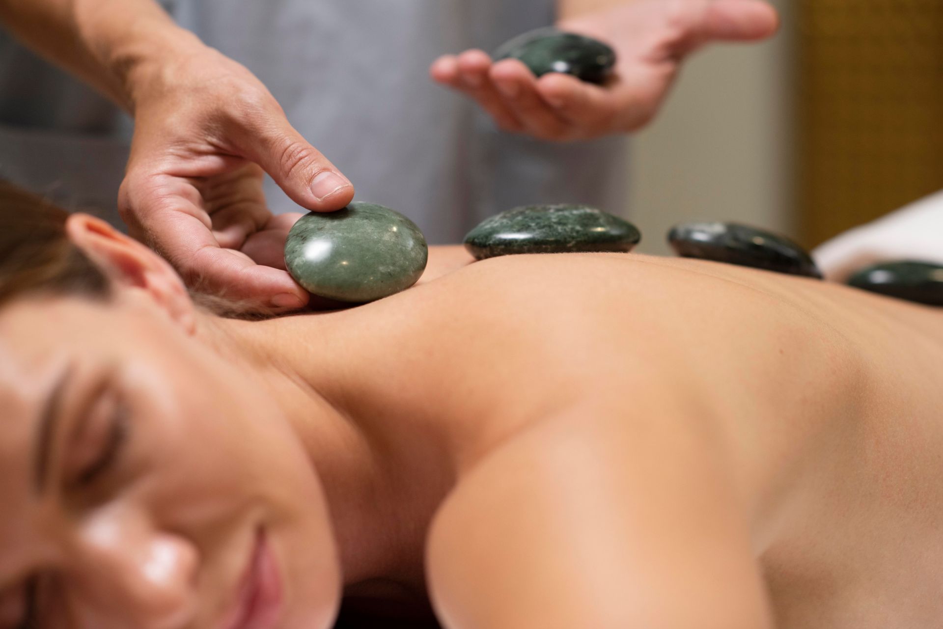 A woman is getting a hot stone massage at a spa.