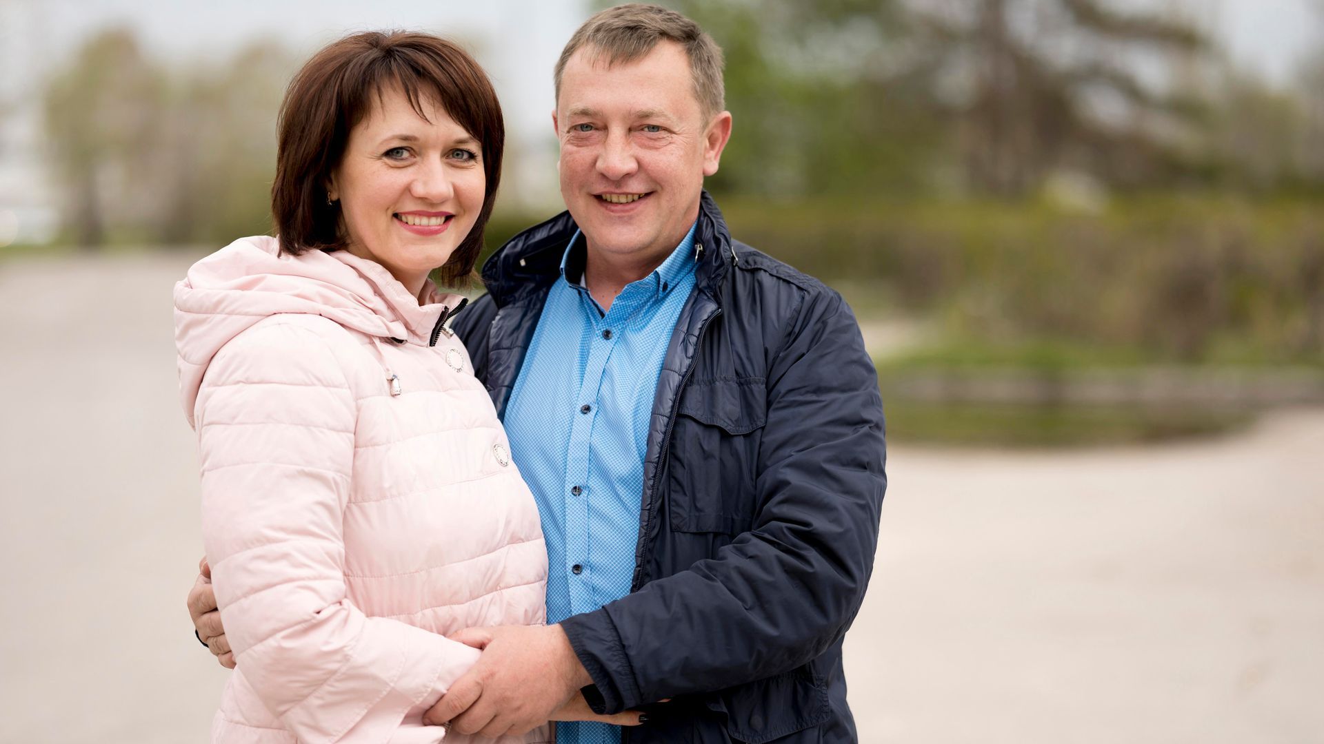 A man and a woman are standing next to each other on a beach.
