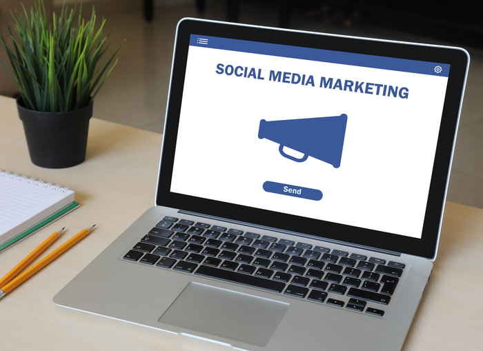 A laptop is open to a screen that says social media marketing