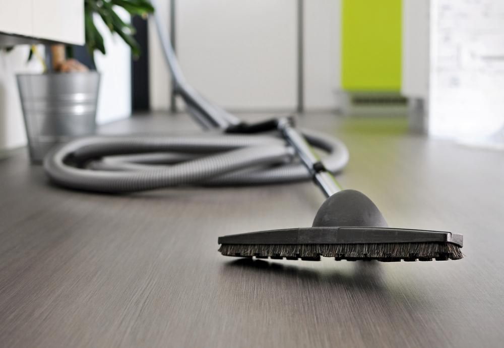 A Vacuum Cleaner Is Laying On A Wooden Floor — Amy's Domestic Agency In Pimlico, QLD