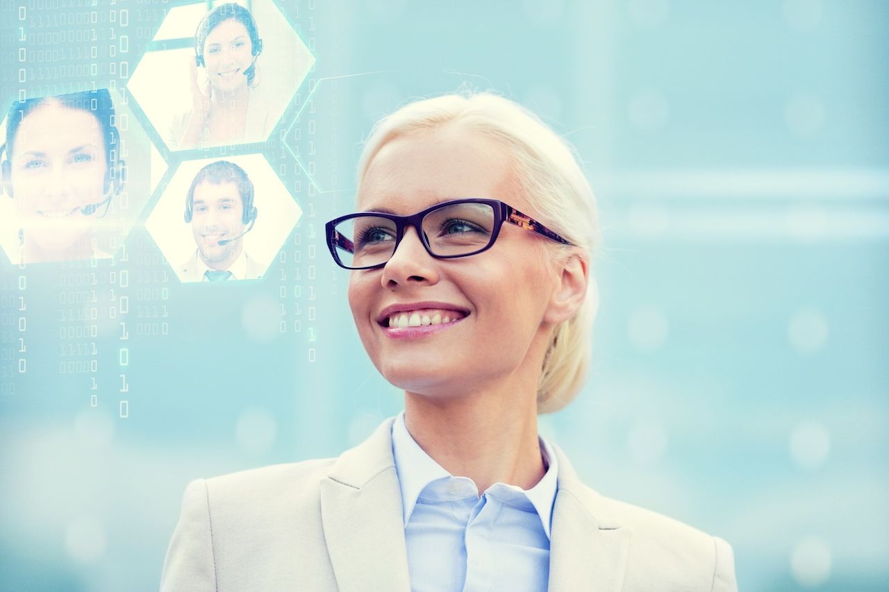 Smiling professional in glasses before a blue digital network background