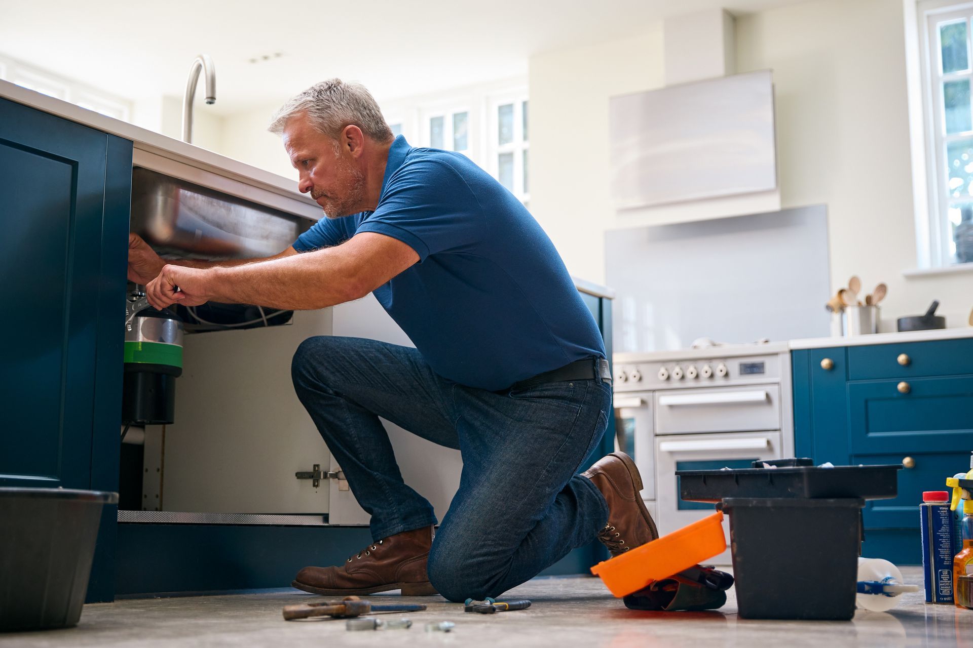 Plumber installing kitchen sink plumbing system.