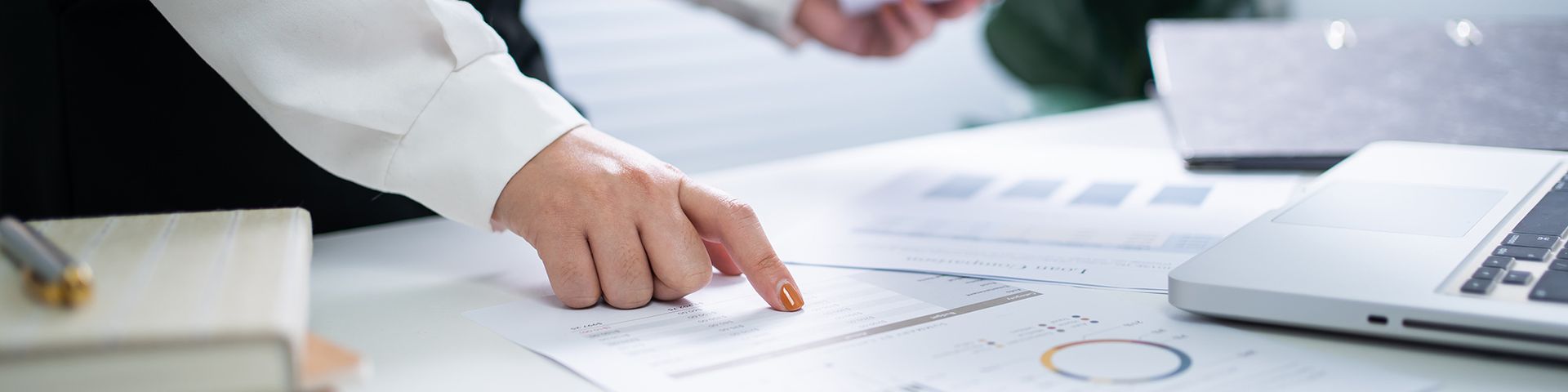 A woman is pointing at a graph on a piece of paper.