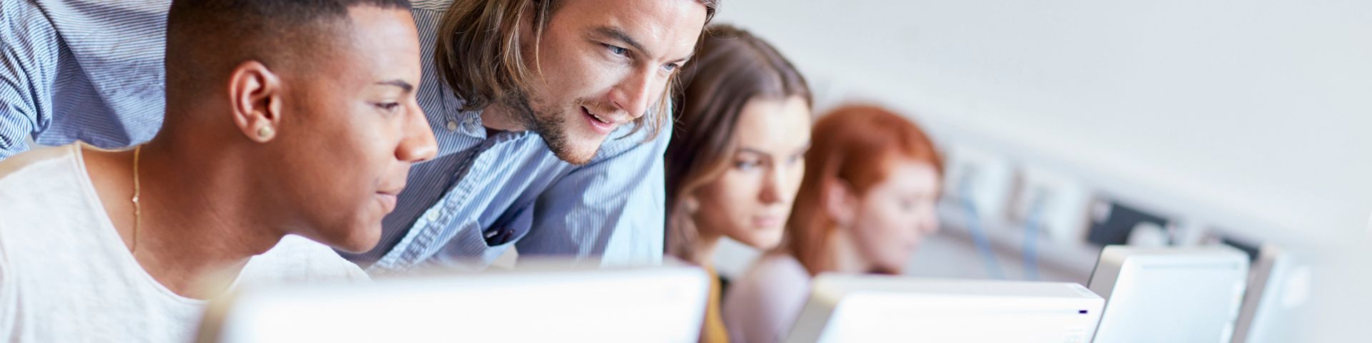 A group of people are looking at a laptop computer.